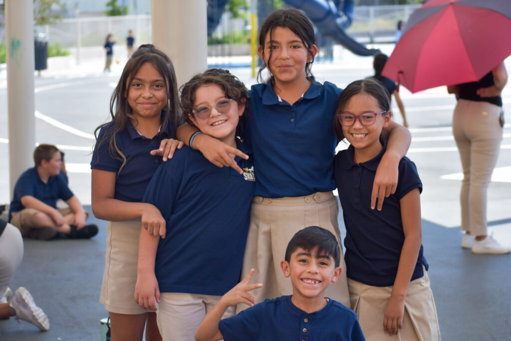 A group of students pose for a photo on the playground.